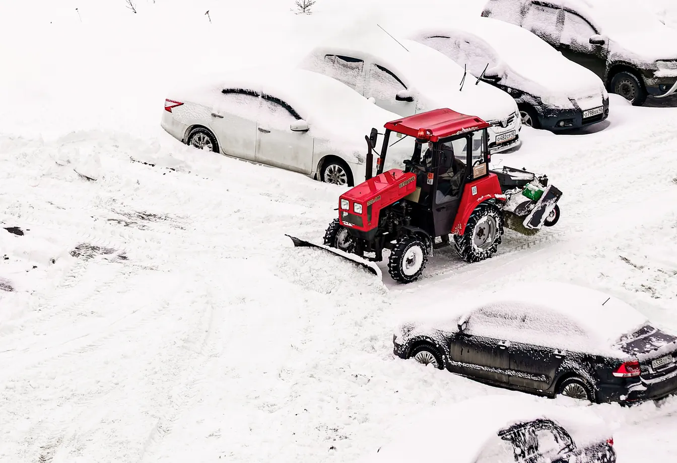 tractor removing snow from a parking lot